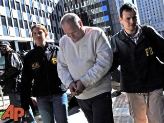 In this Oct, 13, 2010, file photo Michael Dobrushin is led in handcuffs from FBI headquarters in New York. (AP Photo/Louis Lanzano, File)