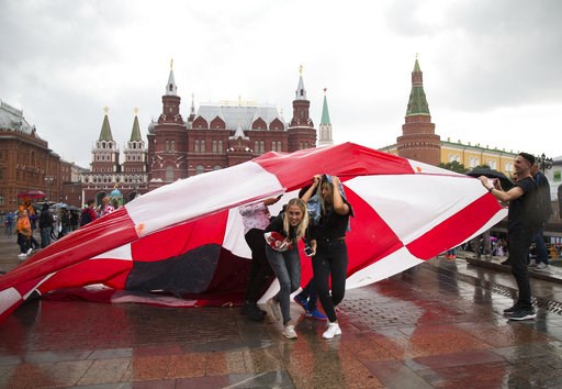 (AP Photo/Alexander Zemlianichenko). Soccer fans use a giant Croatian national flag as a shelter during the rain at Manezh Square near Red Square ahead of the semifinal soccer match between Croatia and England during the 2018 soccer World Cup at the Lu... (AP Photo/Alexander Zemlianichenko). Soccer fans use a giant Croatian national flag as a shelter during the rain at Manezh Square near Red Square ahead of the semifinal soccer match between Croatia and England during the 2018 soccer World Cup at the Lu...