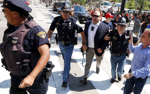 (AP Photo/John Minchillo, File). FILE - In this Tuesday, July 19, 2016 file photo, Alex Jones, center right, is escorted by police out of a crowd of protesters outside the Republican convention in Cleveland. Facebook says it has taken down four pages b... (AP Photo/John Minchillo, File). FILE - In this Tuesday, July 19, 2016 file photo, Alex Jones, center right, is escorted by police out of a crowd of protesters outside the Republican convention in Cleveland. Facebook says it has taken down four pages b...