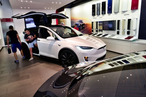 (AP Photo/Richard Vogel). Customers check out the Tesla X, at the Tesla showroom in Santa Monica, Calif., on Wednesday, Aug. 8, 2018. Board members at Tesla are evaluating CEO and Chairman Elon Musk's $72 billion proposal to take the electric car and s... (AP Photo/Richard Vogel). Customers check out the Tesla X, at the Tesla showroom in Santa Monica, Calif., on Wednesday, Aug. 8, 2018. Board members at Tesla are evaluating CEO and Chairman Elon Musk's $72 billion proposal to take the electric car and s...