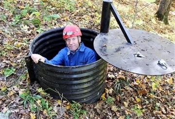 (AP Photo/Jeff Baenen). In this Oct. 10, 2013, photo, John Ackerman poses in a shaft entrance to his Temple of Doom, one of the 37 caves on his property near Spring Valley, Minn. (AP Photo/Jeff Baenen). In this Oct. 10, 2013, photo, John Ackerman poses in a shaft entrance to his Temple of Doom, one of the 37 caves on his property near Spring Valley, Minn.