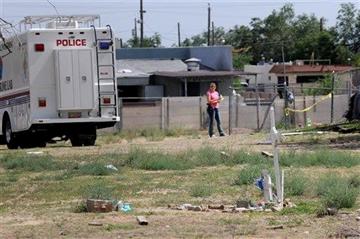 (AP Photo/Albuquerque Journal, Jim Thompson). In a Saturday, July 19, 2014 photo, Albuquerque police work at the scene where two men were found dead in a open area just north of Central Avenue at 60th Street.