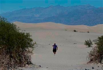 (AP Photo/Chris Carlson). Dan Kail, 67, of Pittsburg Pa., walks thru the sand dunes in Death Vally National Park Friday, June 28, 2013 near Stovepipe Wells, Calif.