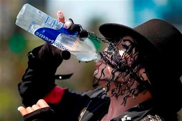 (AP Photo/Julie Jacobson). Michael Jackson impersonator Juan Carlos Gomez drinks some water as he takes a break from posing for photos with tourists along The Strip, Friday, June 28, 2013 in Las Vegas.