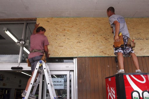 (Gray Whitley/Sun Journal via AP). Robert Patch and John Courtney, of Local Builder's Construction, install wood paneling over windows at the Armstrong Grocery , Tuesday, Sept. 11, 2018, in New Bern, N.C., as storeowners and residents prepare for Hurri... (Gray Whitley/Sun Journal via AP). Robert Patch and John Courtney, of Local Builder's Construction, install wood paneling over windows at the Armstrong Grocery , Tuesday, Sept. 11, 2018, in New Bern, N.C., as storeowners and residents prepare for Hurri...