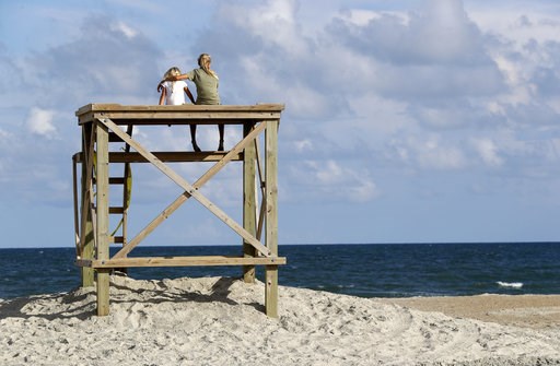 (AP Photo/Chuck Burton). Aubrey Polar, 13, right, of Wilmington, N.C., puts her arm around her sister Sadie Polar, 6, as they look toward the ocean in advance of Hurricane Florence on Wrightsville Beach, N.C., Tuesday, Sept. 11, 2018. (AP Photo/Chuck Burton). Aubrey Polar, 13, right, of Wilmington, N.C., puts her arm around her sister Sadie Polar, 6, as they look toward the ocean in advance of Hurricane Florence on Wrightsville Beach, N.C., Tuesday, Sept. 11, 2018.