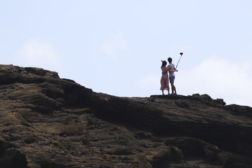(AP Photo/Caleb Jones). A couple stands in the surf as Tropical Storm Olivia approaches Hawaii, Tuesday, Sept. 11, 2018 near Honolulu. The National Weather Service says the storm could dump as much as 20 inches of rain on some parts of the islands as i... (AP Photo/Caleb Jones). A couple stands in the surf as Tropical Storm Olivia approaches Hawaii, Tuesday, Sept. 11, 2018 near Honolulu. The National Weather Service says the storm could dump as much as 20 inches of rain on some parts of the islands as i...