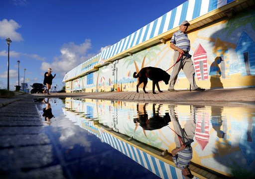 (AP Photo/David Goldman). Beachgoers walk past a mural along the boardwalk as Hurricane Florence approaches the east coast in Atlantic Beach, N.C., Wednesday, Sept. 12, 2018. (AP Photo/David Goldman). Beachgoers walk past a mural along the boardwalk as Hurricane Florence approaches the east coast in Atlantic Beach, N.C., Wednesday, Sept. 12, 2018.