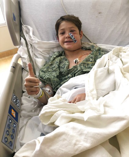 (Shannon Miller via AP). In this Monday, Sept. 10, 2018 photo provided by Shannon Miller, his son Xavier Cunningham, of Harrisonville, Mo., gives a thumbs up while recovering at the University of Kansas Hospital in Kansas City, Kan., after surgery to r... (Shannon Miller via AP). In this Monday, Sept. 10, 2018 photo provided by Shannon Miller, his son Xavier Cunningham, of Harrisonville, Mo., gives a thumbs up while recovering at the University of Kansas Hospital in Kansas City, Kan., after surgery to r...