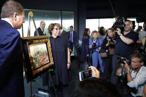 (AP Photo/Mark Lennihan). United States Attorney Geoffrey Berman, left, unveils a Renoir painting with Sylvie Sulitzer at a news conference, Wednesday, Sept. 12, 2018, in New York. The 1919 oil painting "Femmes Dans Un Jardin" was seized in Paris by th... (AP Photo/Mark Lennihan). United States Attorney Geoffrey Berman, left, unveils a Renoir painting with Sylvie Sulitzer at a news conference, Wednesday, Sept. 12, 2018, in New York. The 1919 oil painting "Femmes Dans Un Jardin" was seized in Paris by th...