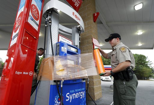 (AP Photo/Chuck Burton). New Hanover Sheriff's Corp. N. Brothers wraps a gas pump for protection in Wilmington, N.C., as Hurricane Florence threatens the coast Thursday, Sept. 13, 2018. (AP Photo/Chuck Burton). New Hanover Sheriff's Corp. N. Brothers wraps a gas pump for protection in Wilmington, N.C., as Hurricane Florence threatens the coast Thursday, Sept. 13, 2018.