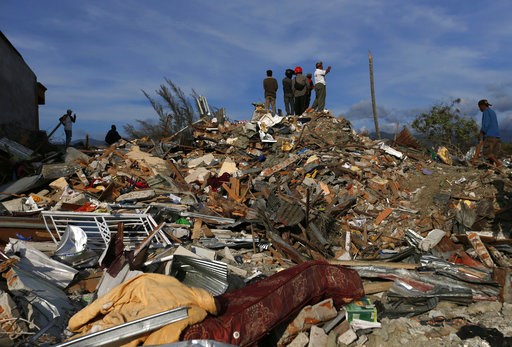 (AP Photo/Dita Alangkara). In this Sunday, Oct. 7, 2018, photo, people stand on top of rubble and dried mud as they survey the damage of the Petobo neighborhood which was wiped out by earthquake-triggered liquefaction in Palu, Central Sulawesi, Indones... (AP Photo/Dita Alangkara). In this Sunday, Oct. 7, 2018, photo, people stand on top of rubble and dried mud as they survey the damage of the Petobo neighborhood which was wiped out by earthquake-triggered liquefaction in Palu, Central Sulawesi, Indones...