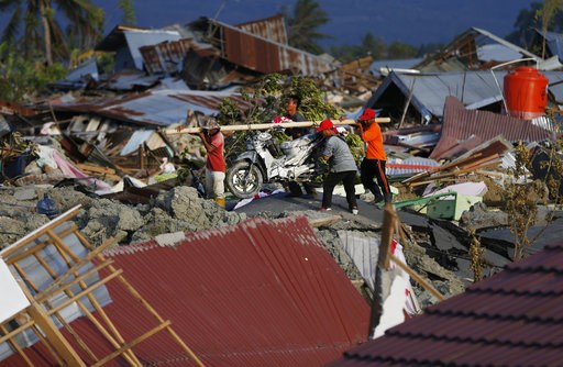 (AP Photo/Dita Alangkara). In this Friday, Oct. 5, 2018, photo, men carry a salvaged motorbike from the Petobo neighborhood wiped out by liquefaction caused by a massive earthquake in Palu, Central Sulawesi, Indonesia. Many in the decimated village had... (AP Photo/Dita Alangkara). In this Friday, Oct. 5, 2018, photo, men carry a salvaged motorbike from the Petobo neighborhood wiped out by liquefaction caused by a massive earthquake in Palu, Central Sulawesi, Indonesia. Many in the decimated village had...