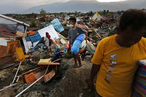 (AP Photo/Dita Alangkara). In this Friday, Oct. 5, 2018, photo, a family carries salvageable items they scavenged from the ruins of their house in the Petobo neighborhood which was wiped out by liquefaction caused by an earthquake in Palu, Central Sula... (AP Photo/Dita Alangkara). In this Friday, Oct. 5, 2018, photo, a family carries salvageable items they scavenged from the ruins of their house in the Petobo neighborhood which was wiped out by liquefaction caused by an earthquake in Palu, Central Sula...