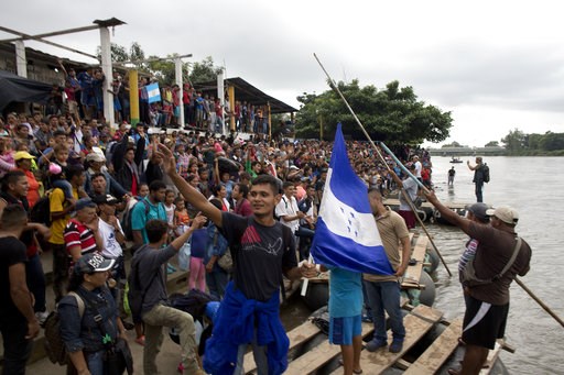 Caravan migrants break Guatemala border fence, rush Mexico