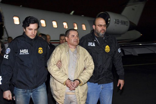 (U.S. law enforcement via AP, File). FILE - In this Jan. 19, 2017 file photo provided U.S. law enforcement, authorities escort Joaquin "El Chapo" Guzman, center, from a plane to a waiting caravan of SUVs at Long Island MacArthur Airport, in Ronkonkoma,...