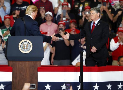 (AP Photo/Jeff Roberson). President Donald Trump shakes hands with Fox News Channel's Sean Hannity, right, during a campaign rally Monday, Nov. 5, 2018, in Cape Girardeau, Mo.