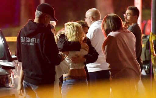 (AP Photo/Mark J. Terrill). People comfort each other as they stand near the scene Thursday, Nov. 8, 2018, in Thousand Oaks, Calif., where a gunman opened fire Wednesday inside a country dance bar crowded with hundreds of people on "college night," wou... (AP Photo/Mark J. Terrill). People comfort each other as they stand near the scene Thursday, Nov. 8, 2018, in Thousand Oaks, Calif., where a gunman opened fire Wednesday inside a country dance bar crowded with hundreds of people on "college night," wou...