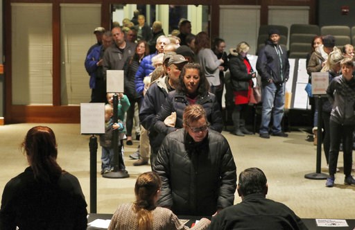 (John R. Ehlke /West Bend Daily News via AP). Julie Skomski checks in with a line of people behind her on Tuesday, Nov. 6, 2018 while voting in the midterm election at the District No. 4 location at CrossWay Church in Germantown, Wis. (John R. Ehlke /West Bend Daily News via AP). Julie Skomski checks in with a line of people behind her on Tuesday, Nov. 6, 2018 while voting in the midterm election at the District No. 4 location at CrossWay Church in Germantown, Wis.