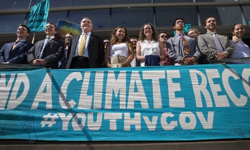 (Chris Pietsch/The Register-Guard via AP, File). FILE - In this July 18, 2018, file photo, lawyers and youth plaintiffs lineup behind a banner after a hearing before Federal District Court Judge Ann Aiken between lawyers for the Trump Administration an... (Chris Pietsch/The Register-Guard via AP, File). FILE - In this July 18, 2018, file photo, lawyers and youth plaintiffs lineup behind a banner after a hearing before Federal District Court Judge Ann Aiken between lawyers for the Trump Administration an...