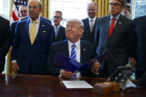 (AP Photo/Evan Vucci, File). FILE - In this March 24, 2017 file photo, President Donald Trump, flanked by Commerce Secretary Wilbur Ross, left, and Energy Secretary Rick Perry, is seen in the Oval Office of the White House in Washington, during the ann... (AP Photo/Evan Vucci, File). FILE - In this March 24, 2017 file photo, President Donald Trump, flanked by Commerce Secretary Wilbur Ross, left, and Energy Secretary Rick Perry, is seen in the Oval Office of the White House in Washington, during the ann...