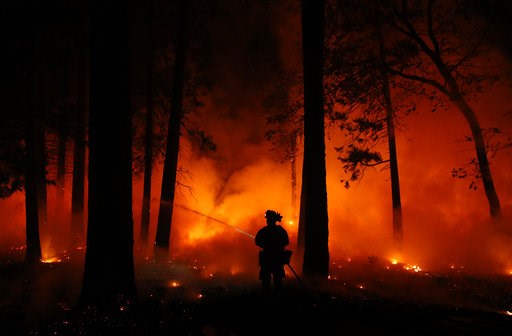 (AP Photo/John Locher). A firefighter sprays water on a controlled burn at a wildfire, Friday, Nov. 9, 2018, in Magalia, Calif. (AP Photo/John Locher). A firefighter sprays water on a controlled burn at a wildfire, Friday, Nov. 9, 2018, in Magalia, Calif.
