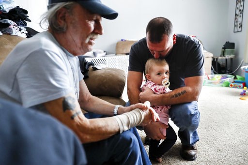 (AP Photo/John Minchillo). In this Nov. 28, 2018 photo, Tom Wolikow, right, holds his daughter Annabella alongside his father John, left, at their home in Warren, Ohio. It was working-class voters who bucked the area's history as a Democratic stronghol... (AP Photo/John Minchillo). In this Nov. 28, 2018 photo, Tom Wolikow, right, holds his daughter Annabella alongside his father John, left, at their home in Warren, Ohio. It was working-class voters who bucked the area's history as a Democratic stronghol...