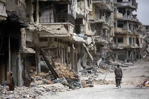 (AP Photo/Dusan Vranic, File). FILE - In this June 5, 2014, file photo, a man rides a bicycle through a part of Homs, Syria, devastated by the country's civil war. Climate Change is more than rising thermometers, wildfires, droughts and storms; it even... (AP Photo/Dusan Vranic, File). FILE - In this June 5, 2014, file photo, a man rides a bicycle through a part of Homs, Syria, devastated by the country's civil war. Climate Change is more than rising thermometers, wildfires, droughts and storms; it even...