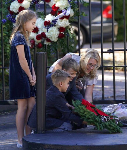 (AP Photo/David J. Phillip). Tiffany Utterson, right, and her children, from left to right, Ella, 11, Ian, 10 and Owen, 8, place a wreath outside the gated community entrance to the home of George H.W. Bush Sunday, Dec. 2, 2018, in Houston. Bush is ret... (AP Photo/David J. Phillip). Tiffany Utterson, right, and her children, from left to right, Ella, 11, Ian, 10 and Owen, 8, place a wreath outside the gated community entrance to the home of George H.W. Bush Sunday, Dec. 2, 2018, in Houston. Bush is ret...