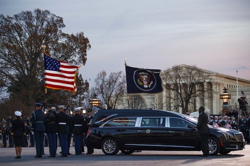 (Shawn Thew/Pool Photo via AP). A joint services military honor guard removes the casket of former President George H.W. Bush from the hearse to carry it into the rotunda of the U.S. Capitol in Washington to lie in state, Monday, Dec. 3, 2018. (Shawn Thew/Pool Photo via AP). A joint services military honor guard removes the casket of former President George H.W. Bush from the hearse to carry it into the rotunda of the U.S. Capitol in Washington to lie in state, Monday, Dec. 3, 2018.