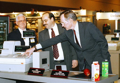 (AP Photo/Barry Thumma). FILE - In this Feb. 4, 1992 file photo, President George H. W. Bush, right, pushes the keys on a new high technology cash register under the watchful eyes of Leo Hardy, left, and Bob Graham, center, during a visit to the Nation... (AP Photo/Barry Thumma). FILE - In this Feb. 4, 1992 file photo, President George H. W. Bush, right, pushes the keys on a new high technology cash register under the watchful eyes of Leo Hardy, left, and Bob Graham, center, during a visit to the Nation...