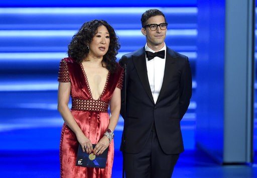 (Photo by Chris Pizzello/Invision/AP, File). FILE - In this Sept. 17, 2018 file photo, Sandra Oh, left, and Andy Samberg present an award at the 70th Primetime Emmy Awards in Los Angeles. Oh and Samberg will share host duties at next month’s Golden Glo...
