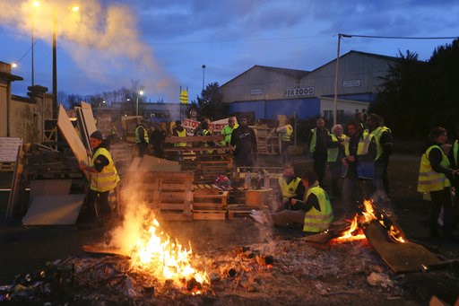 (AP Photo/David Vincent). FILE - In this Tuesday, Dec. 5, 2018 file photo, demonstrators stand at a makeshift barricade set up by the "yellow jackets" protesters to block the entrance of a fuel depot in Le Mans, western France. Even proponents of carbo... (AP Photo/David Vincent). FILE - In this Tuesday, Dec. 5, 2018 file photo, demonstrators stand at a makeshift barricade set up by the "yellow jackets" protesters to block the entrance of a fuel depot in Le Mans, western France. Even proponents of carbo...