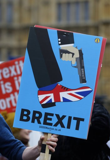 (AP Photo/Kirsty Wigglesworth). An anti-Brexit campaigner holds a banner in front of parliament in London, Wednesday, Dec. 5, 2018. Britain's Brexit debate has become a bruising battle between lawmakers and Prime Minister Theresa May's government. May ... (AP Photo/Kirsty Wigglesworth). An anti-Brexit campaigner holds a banner in front of parliament in London, Wednesday, Dec. 5, 2018. Britain's Brexit debate has become a bruising battle between lawmakers and Prime Minister Theresa May's government. May ...