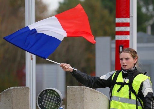(AP Photo/Bob Edme). A demonstrator holds a french flag at the toll gates on a motorway at Biarritz southwestern France, Wednesday, Dec. 5, 2018.T he concessions made by French president Emmanuel Macron's government in a bid to stop the huge and violen... (AP Photo/Bob Edme). A demonstrator holds a french flag at the toll gates on a motorway at Biarritz southwestern France, Wednesday, Dec. 5, 2018.T he concessions made by French president Emmanuel Macron's government in a bid to stop the huge and violen...