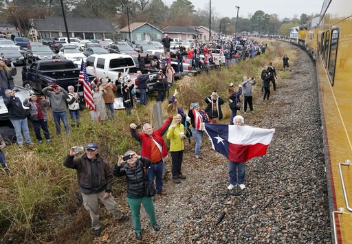 (AP Photo/David J. Phillip, Pool). People pay their respects as the train carrying the casket of former President George H.W. Bush passes Thursday, Dec. 6, 2018, along the route from Spring to College Station, Texas. (AP Photo/David J. Phillip, Pool). People pay their respects as the train carrying the casket of former President George H.W. Bush passes Thursday, Dec. 6, 2018, along the route from Spring to College Station, Texas.