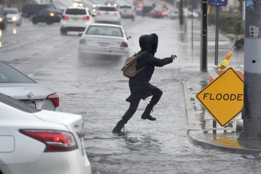 (James Quigg/The Daily Press via AP). A pedestrian leaps across a flooded portion of the La Paz and Seventh Street intersection as a winter storm arrived, Thursday, Dec. 6, 2018 in Victorville, Calif. The second round of a fall storm dumped snow and ra... (James Quigg/The Daily Press via AP). A pedestrian leaps across a flooded portion of the La Paz and Seventh Street intersection as a winter storm arrived, Thursday, Dec. 6, 2018 in Victorville, Calif. The second round of a fall storm dumped snow and ra...