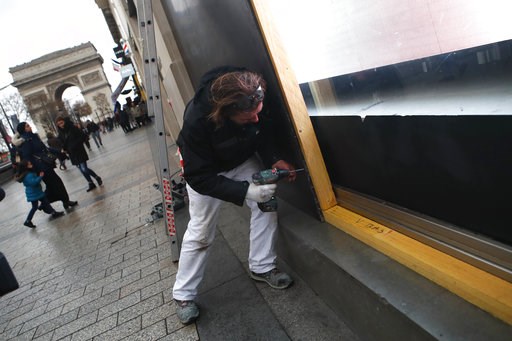 (AP Photo/Francois Mori). A worker screws a wooden plank to protect a shop windows on the Champs-Elysees avenue, Friday, Dec. 7, 2018 in Paris. Many shop owners across the French capital are getting ready for the violence, setting up walls with carton ... (AP Photo/Francois Mori). A worker screws a wooden plank to protect a shop windows on the Champs-Elysees avenue, Friday, Dec. 7, 2018 in Paris. Many shop owners across the French capital are getting ready for the violence, setting up walls with carton ...
