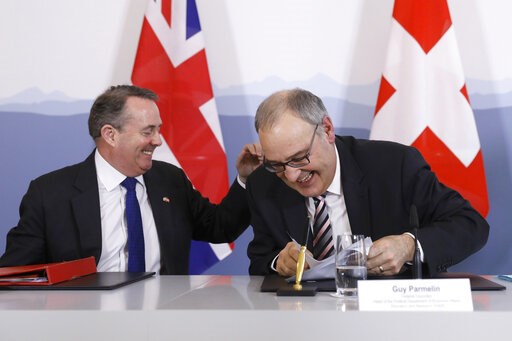 (Peter Klaunzer/Keystone via AP). Swiss Federal Councillor Guy Parmelin, right, and British Secretary of State for International Trade Liam Fox, left, react after signing a trade agreement in Bern, Switzerland, Monday, Feb. 11, 2019. Parmelin and Fox s... (Peter Klaunzer/Keystone via AP). Swiss Federal Councillor Guy Parmelin, right, and British Secretary of State for International Trade Liam Fox, left, react after signing a trade agreement in Bern, Switzerland, Monday, Feb. 11, 2019. Parmelin and Fox s...
