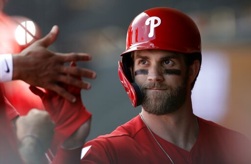 (AP Photo/Chris O'Meara). Philadelphia Phillies' Bryce Harper high-fives teammates after being taken out during the third inning of a spring training baseball game against the Toronto Blue Jays, Saturday, March 9, 2019, in Clearwater, Fla.