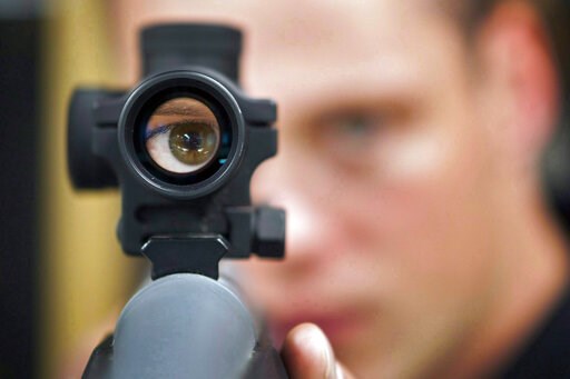 (Jeff McIntosh/The Canadian Press via AP). FILE - In this Sept. 15, 2010 file photo, an employee looks through the scope of long gun at a gun store in Calgary, Alberta, Canada. When Canada first sought to restrict gun access in the 1990s, the National ... (Jeff McIntosh/The Canadian Press via AP). FILE - In this Sept. 15, 2010 file photo, an employee looks through the scope of long gun at a gun store in Calgary, Alberta, Canada. When Canada first sought to restrict gun access in the 1990s, the National ...