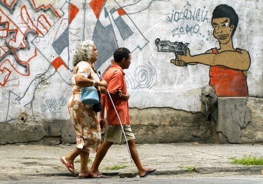 (AP Photo/Renzo Gostoli, File). FILE - In this Oct. 22, 2005 file photo, people walk past graffiti in Rio de Janeiro, Brazil, a day before a vote to ban the sale of firearms and ammunition to civilians. Backed by the Roman Catholic church and other pow... (AP Photo/Renzo Gostoli, File). FILE - In this Oct. 22, 2005 file photo, people walk past graffiti in Rio de Janeiro, Brazil, a day before a vote to ban the sale of firearms and ammunition to civilians. Backed by the Roman Catholic church and other pow...