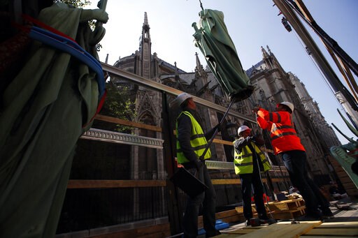 (AP Photo/Francois Mori). Workers secure a religious statue perched atop Paris' Notre Dame Cathedral as it descends to earth for the first time in over a century as part of a restoration, in Paris Thursday, April 11, 2019. The 16 greenish-gray copper s... (AP Photo/Francois Mori). Workers secure a religious statue perched atop Paris' Notre Dame Cathedral as it descends to earth for the first time in over a century as part of a restoration, in Paris Thursday, April 11, 2019. The 16 greenish-gray copper s...