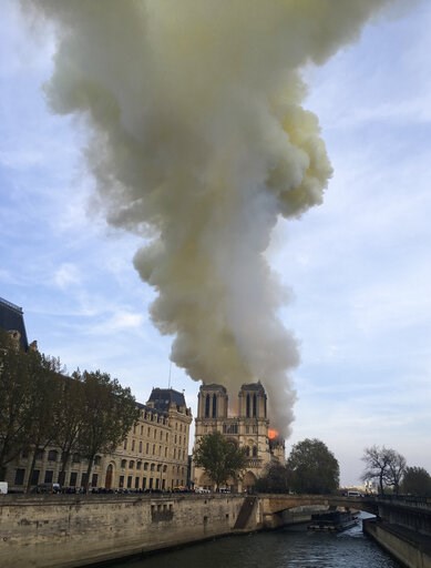 (AP Photo/Lori Hinant). Notre Dame cathedral is burning in Paris, Monday, April 15, 2019. Massive plumes of yellow brown smoke is filling the air above Notre Dame Cathedral and ash is falling on tourists and others around the island that marks the cent... (AP Photo/Lori Hinant). Notre Dame cathedral is burning in Paris, Monday, April 15, 2019. Massive plumes of yellow brown smoke is filling the air above Notre Dame Cathedral and ash is falling on tourists and others around the island that marks the cent...