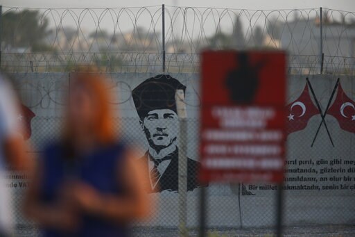 (AP Photo/Lefteris Pitarakis). A graffiti of modern Turkey's founder Mustafa Kemal Ataturk is seen on the Turkish side of the border between Turkey and Syria, as a TV journalist works in Akcakale, Sanliurfa province, southeastern Turkey, Tuesday, Oct. ... (AP Photo/Lefteris Pitarakis). A graffiti of modern Turkey's founder Mustafa Kemal Ataturk is seen on the Turkish side of the border between Turkey and Syria, as a TV journalist works in Akcakale, Sanliurfa province, southeastern Turkey, Tuesday, Oct. ...