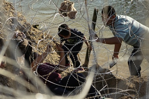 As migrants overwhelm a Texas border city, others wait in Mexico for appointments to enter the US